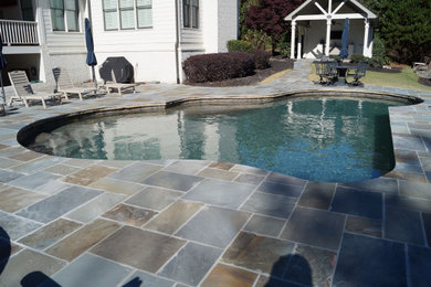 Large elegant backyard stone patio photo in Atlanta with a gazebo