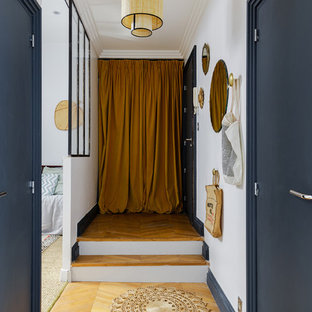 Inspiration för mellanstora eklektiska entréer, med vita väggar, ljust trägolv och en enkeldörr