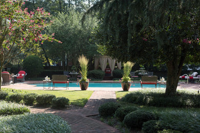 Example of a mid-sized classic backyard brick pool design in Richmond