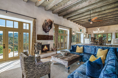 This is an example of an eclectic open concept living room in Albuquerque with beige walls, a standard fireplace, a plaster fireplace surround and no tv.