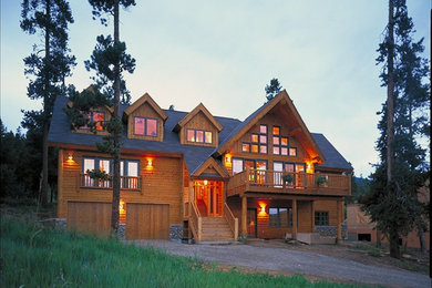 Photo of a large country two-storey brown exterior in Denver with wood siding and a gable roof.