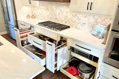 Open concept kitchen - large transitional u-shaped medium tone wood floor and brown floor open concept kitchen idea in Other with an undermount sink, flat-panel cabinets, white cabinets, quartz countertops, multicolored backsplash, stone tile backsplash, stainless steel appliances, an island and white countertops