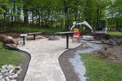 Photo of a mid-sized country backyard partial sun garden in New York with a fire feature and concrete pavers.