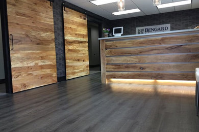 Example of a built-in desk dark wood floor study room design in Omaha with gray walls
