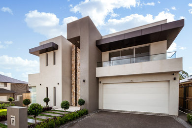 Large contemporary two-storey concrete grey house exterior in Sydney with a flat roof and a metal roof.