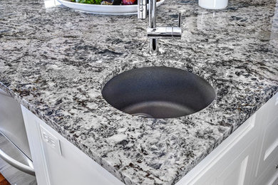 Eat-in kitchen - mid-sized transitional l-shaped medium tone wood floor eat-in kitchen idea in St Louis with an undermount sink, beaded inset cabinets, white cabinets, granite countertops, paneled appliances and an island
