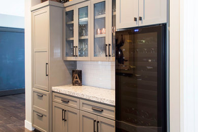 Example of a transitional single-wall wet bar design in Sacramento with recessed-panel cabinets, beige cabinets, white backsplash and subway tile backsplash
