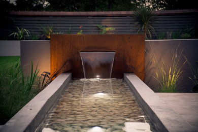 Design ideas for a mid-sized contemporary backyard garden in Cheshire with a water feature.