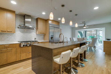 Open concept kitchen - mid-sized contemporary l-shaped light wood floor open concept kitchen idea in Dallas with flat-panel cabinets, medium tone wood cabinets, quartz countertops, an island, an undermount sink, multicolored backsplash, stone slab backsplash and stainless steel appliances