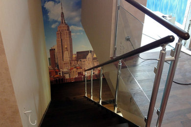 Cette image montre un grand escalier bohème en U avec des marches en bois et un garde-corps en matériaux mixtes.