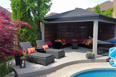Example of a large minimalist backyard ground level deck design in Toronto