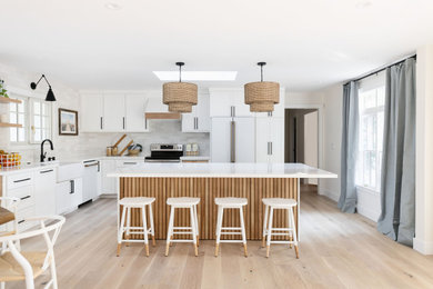Large beach style open concept kitchen photo in San Francisco with shaker cabinets, white cabinets, quartz countertops and an island