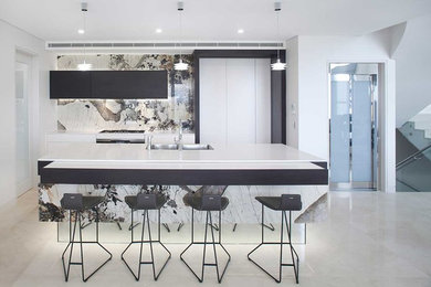Small contemporary u-shaped eat-in kitchen with a double-bowl sink, white cabinets, quartz benchtops, multi-coloured splashback, stone slab splashback, stainless steel appliances and with island.