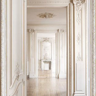 Bild på en vintage hall, med vita väggar och ljust trägolv