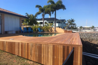 Contemporary backyard kidney-shaped lap pool in Brisbane with decking.