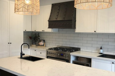 Traditional l-shaped kitchen in Melbourne with a single-bowl sink, beaded inset cabinets, white cabinets, marble benchtops, white splashback, subway tile splashback and white benchtop.