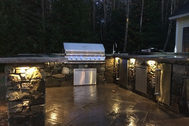 Design ideas for a mid-sized traditional partial sun backyard stone landscaping in Portland Maine for spring.