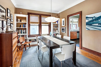 Inspiration for a transitional medium tone wood floor dining room remodel in Other with brown walls