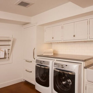 シアトルのトラディショナルスタイルのおしゃれなランドリールーム (エプロンフロントシンク、白いキャビネット、亜鉛製カウンター、コンクリートの床、左右配置の洗濯機・乾燥機) の写真