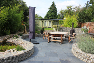 Design ideas for a patio in Essex with natural stone pavers.