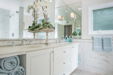 Large transitional master bathroom in Orange County with beaded inset cabinets, white cabinets, an alcove shower, beige tile, white tile, marble, beige walls, porcelain floors, an integrated sink, engineered quartz benchtops, beige floor and a hinged shower door.