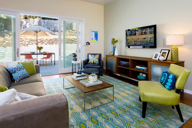 This is an example of a mid-sized contemporary open concept family room in San Francisco with a wall-mounted tv, beige walls, bamboo floors and brown floor.