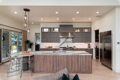 Example of a large galley light wood floor and brown floor kitchen pantry design in Denver with a single-bowl sink, flat-panel cabinets, medium tone wood cabinets, quartz countertops, white backsplash, quartz backsplash, stainless steel appliances, an island and white countertops