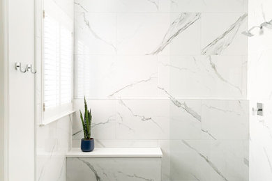 Shower bench - modern master white tile black floor and double-sink shower bench idea in Nashville with flat-panel cabinets, blue cabinets, white walls, quartz countertops, white countertops and a built-in vanity