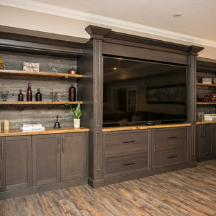 This is an example of a large rustic open plan home cinema in Toronto with grey walls, vinyl flooring, a built-in media unit and brown floors.