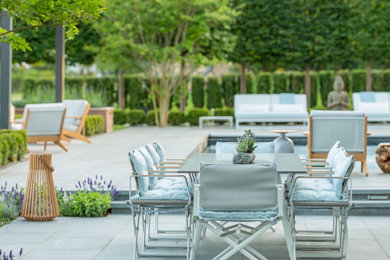Inspiration for a large modern courtyard patio remodel in Other with a pergola