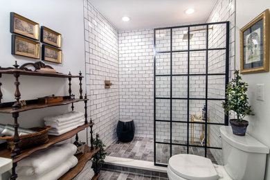 This is an example of a mid-sized transitional master bathroom in Charlotte with white tile, subway tile, white walls, ceramic floors, grey floor, an open shower, an alcove shower and a two-piece toilet.