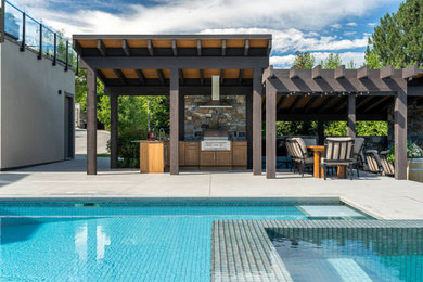 Example of a large classic backyard concrete patio kitchen design in Other with a pergola