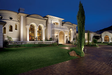 Huge tuscan gray two-story stucco house exterior photo in Phoenix with a hip roof, a mixed material roof and a gray roof