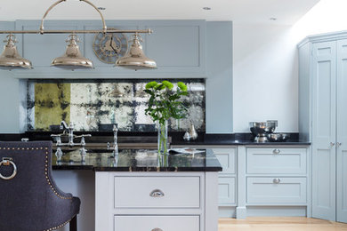 This is an example of a large transitional eat-in kitchen in Kent with beaded inset cabinets, grey cabinets, granite benchtops, metallic splashback, mirror splashback, stainless steel appliances, medium hardwood floors, with island and an undermount sink.