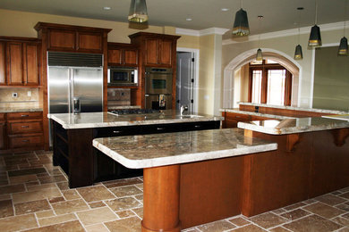 Eat-in kitchen - large galley slate floor eat-in kitchen idea in Other with medium tone wood cabinets, beige backsplash, ceramic backsplash and stainless steel appliances