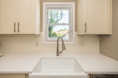 Inspiration for a small transitional l-shaped vinyl floor and beige floor enclosed kitchen remodel in Baltimore with a farmhouse sink, shaker cabinets, beige cabinets, quartz countertops, white backsplash, ceramic backsplash, stainless steel appliances, no island and white countertops