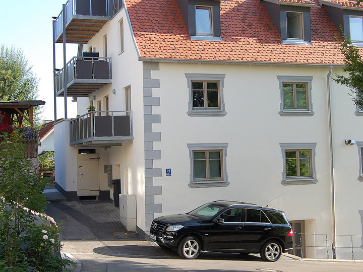 Example of a large classic white three-story concrete gable roof design