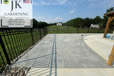 Large minimalist backyard stone and custom-shaped aboveground pool landscaping photo in DC Metro