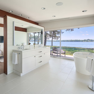 Foto di una grande stanza da bagno padronale moderna con ante lisce, ante bianche, vasca freestanding, lavabo sottopiano, pavimento bianco, piastrelle bianche, piastrelle diamantate, pareti bianche, pavimento con piastrelle in ceramica e top in superficie solida