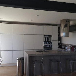 Large contemporary kitchen pantry pictures - Example of a large trendy galley light wood floor and beige floor kitchen pantry design in Marseille with an undermount sink, recessed-panel cabinets, white cabinets, laminate countertops, stainless steel appliances and no island