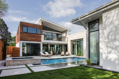 Inspiration for a large contemporary white two-story stucco exterior home remodel in Dallas with a shed roof