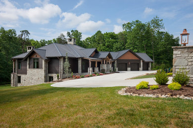 Inspiration for a rustic brown two-story mixed siding house exterior remodel in Other with a hip roof and a metal roof