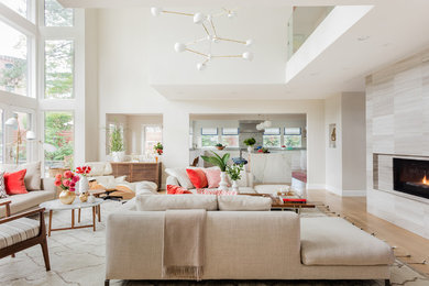 Trendy open concept light wood floor living room photo in Boston with beige walls, a two-sided fireplace and a stone fireplace
