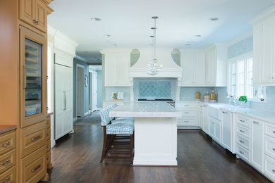 Mid-sized transitional eat-in kitchen in Kansas City with a farmhouse sink, recessed-panel cabinets, white cabinets, marble benchtops, blue splashback, medium hardwood floors, with island and panelled appliances.