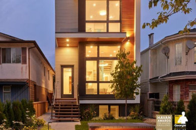 Inspiration for a mid-sized contemporary three-storey grey house exterior in Vancouver with mixed siding, a flat roof, a shingle roof, a black roof and clapboard siding.