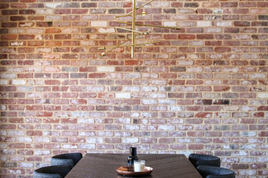 Large industrial dining room in Perth with beige walls, vinyl floors, vaulted and brick walls.