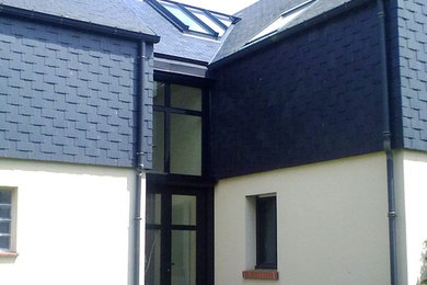 Modelo de fachada de casa pareada actual de tamaño medio de tres plantas con revestimiento de vidrio, tejado a dos aguas y tejado de varios materiales