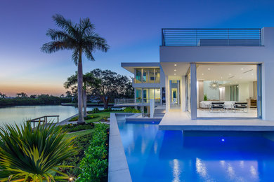 Inspiration for a large modern backyard custom-shaped aboveground pool in Tampa with concrete pavers.