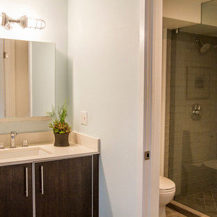 Esempio di una piccola stanza da bagno con doccia industriale con ante lisce, ante in legno bruno, doccia alcova, WC monopezzo, piastrelle grigie, piastrelle di vetro, pareti blu, pavimento in gres porcellanato, lavabo sottopiano e top in quarzo composito