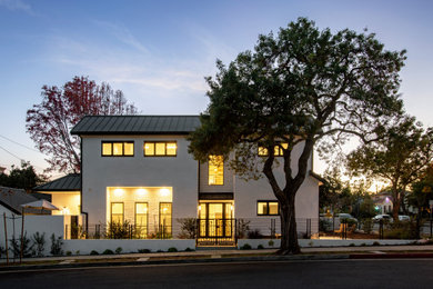 Mid-sized contemporary white stucco house exterior idea in Los Angeles with a hip roof, a metal roof and a black roof